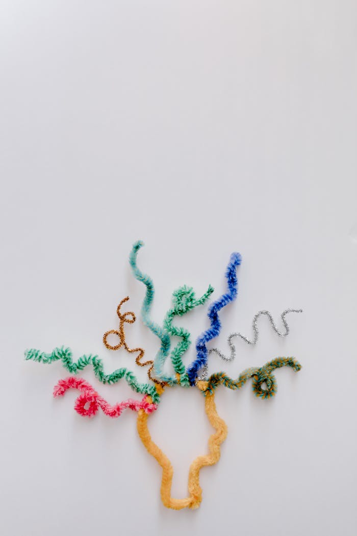 Creative arrangement of colorful pipe cleaners resembling a brain on a white background.